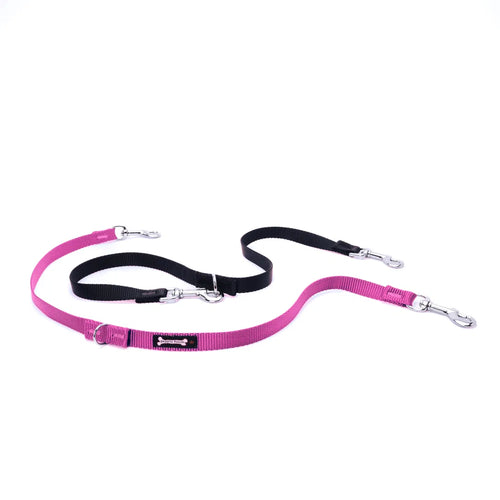 Hot Pink and black multi-function dog leash on a white background, with silver clasps and D-rings at each adjustable point, plus a 'Smoochy Poochy' fabric tag on the teal strap.