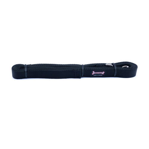 Black nylon dog leash lying flat, folded into loops and secured with black zip ties, showing a metal clip loop at one end
