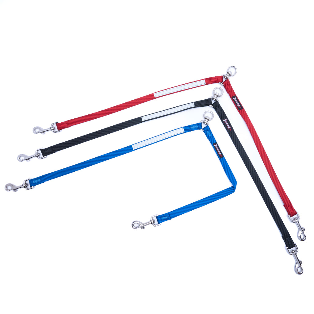 Three dual-dog leash splitters (red, black, and blue) shown side by side on a white background, each with two clasps that connect to a single ring, letting one leash walk two dogs at once.