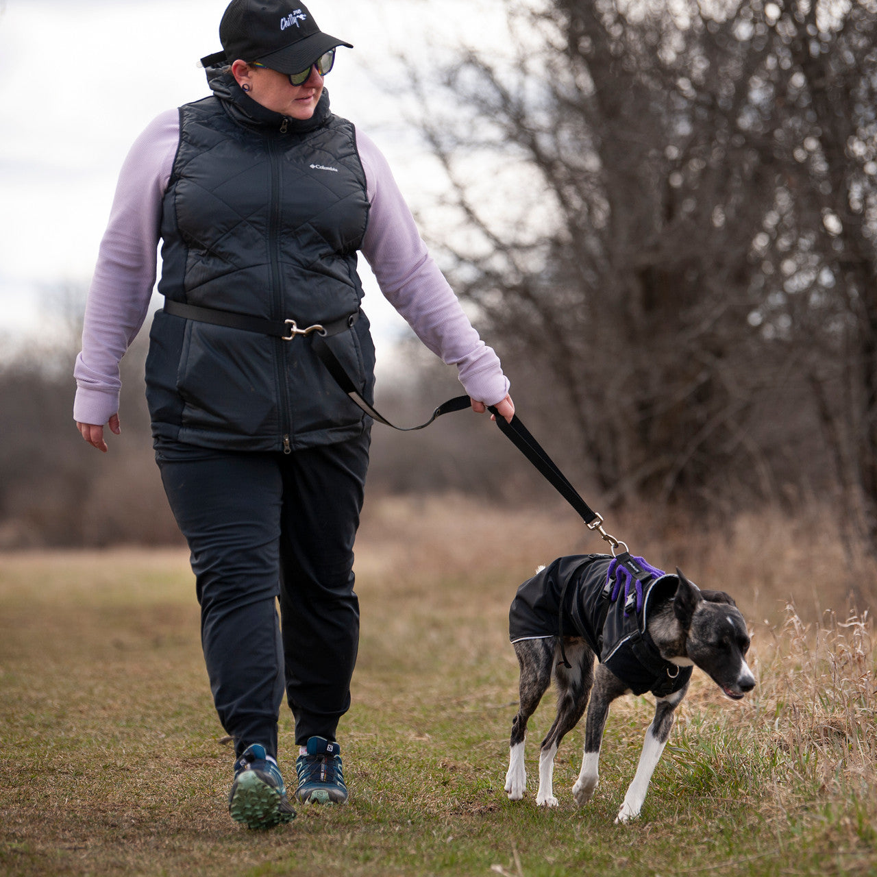 Smoochy Poochy hands-free leash in use, attached to a dog being walked by a person on a grassy path.