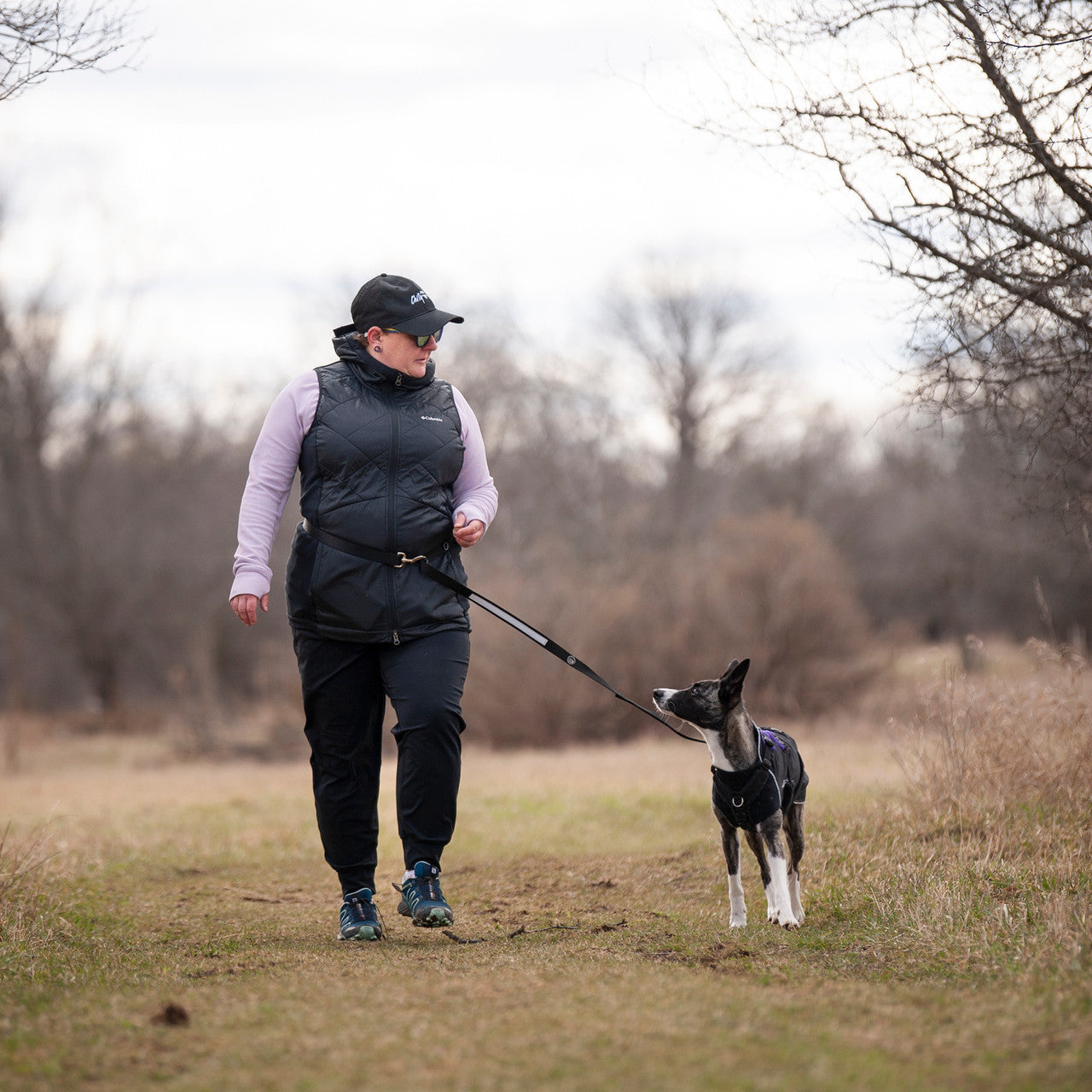 Smoochy Poochy hands-free leash, 6ft, in use by a person walking a dog on a grassy path in a natural setting.