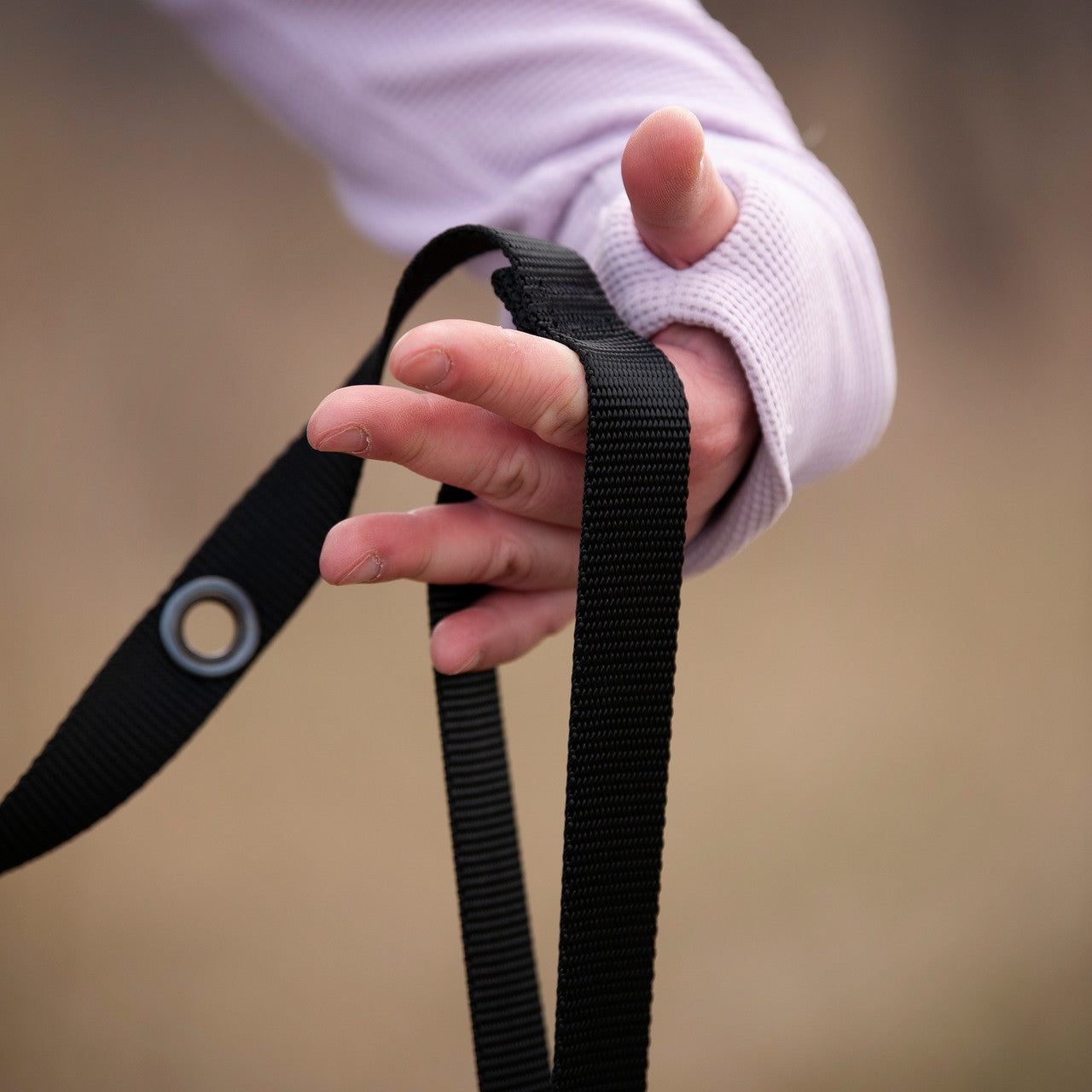 Smoochy Poochy hands-free leash with a black strap held by a hand, featuring a traffic handle for better control.